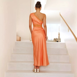 Vue arrière d'une robe longue en satin orange à une épaule portée par un mannequin