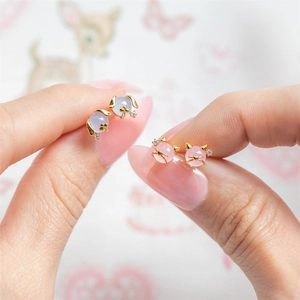 Detail of pink cat and blue rabbit stud earrings with gold plating and zircons