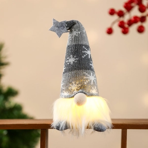 Close-up of a glowing Christmas gnome with star hat and snowflake knit texture