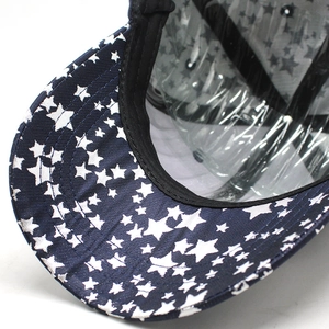 Detail of navy baseball cap with white star print and precise brim stitching
