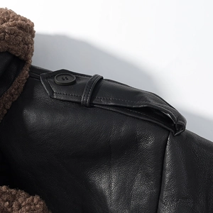 Detail of shoulder epaulette and brown faux fur collar on black leather jacket