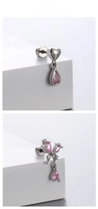 Detail of pink crystal butterfly and heart drop earrings in polished titanium steel