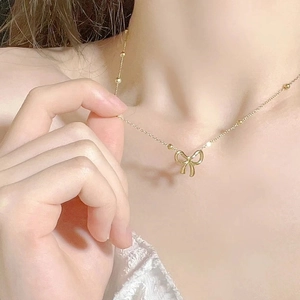 Elegant gold titanium steel bow bracelet with tiny beads for women on a stylish wrist