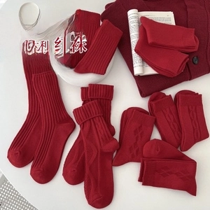 Detailed view of red thermal crew socks with cable knit patterns in a lifestyle setting