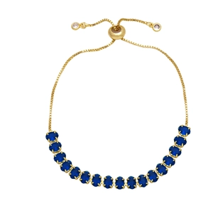 Detail of adjustable gold-plated bolo bracelet featuring oval-cut dark blue zircons