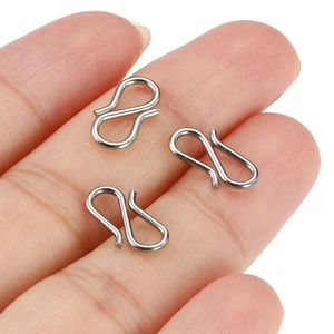 Polished silver stainless steel S-hooks for jewelry making shown on a fingertip