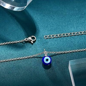 Macro shot of silver-tone stainless steel evil eye pendant necklace with lobster clasp