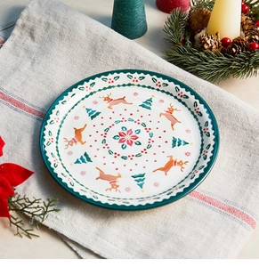 Close-up of a ceramic Christmas plate with reindeer and pine tree festive patterns