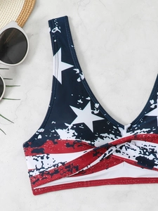 Close-up of American flag print bikini top with twist-knot detail on marble surface