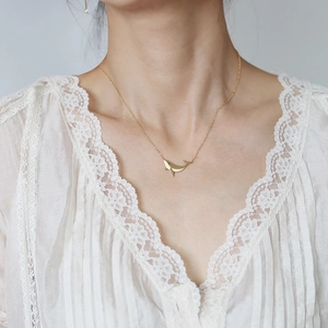 Bohemian whale tail necklace in 18K gold plated titanium steel worn on neck