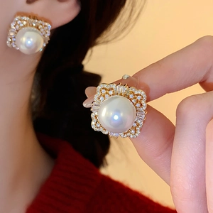 Close-up detail of vintage square pearl stud earrings with zircon crystals in gold plating