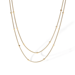 Double-layered gold snake chain necklace with circular disc charms on white background