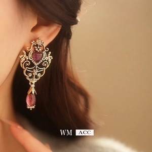 Vintage baroque gold earrings with purple heart stone and drop pendant on a model
