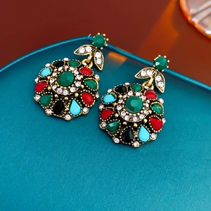 Macro detail of vintage floral earrings with colorful crystals and gold metal setting