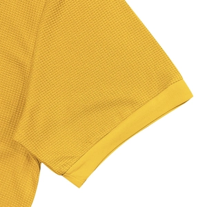 Close-up of yellow waffle knit polo shirt sleeve showing detailed texture and stitching