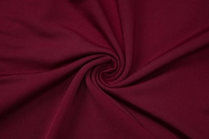 Gros plan sur le tissu en maille côtelée bordeaux montrant la texture et la matière