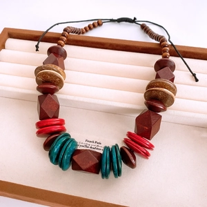 Detail of bohemian necklace with textured brown wood blocks and colorful coconut shell beads