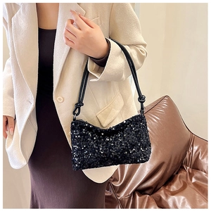 Close-up of black sequin shoulder bag featuring fine texture and knotted strap detail