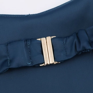 Detailed close-up of dark blue fabric featuring a premium gold metallic buckle closure