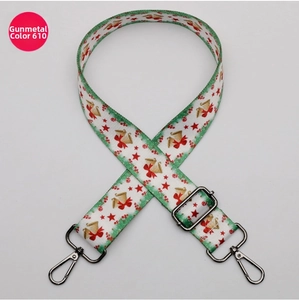 Close-up of adjustable Christmas crossbody strap with gunmetal hardware and bell patterns