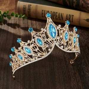 Detailed close-up of a luxury baroque blue crystal tiara, sparkling rhinestones on gold crown.