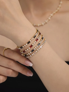 Close-up of gold layered tennis bracelets with colorful rectangular zircon gemstones