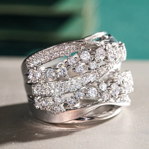 Close-up of a layered silver-toned wide ring with pavé-set white sparkling rhinestones