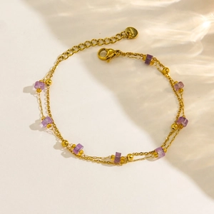 Détail du bracelet en acier doré 14K avec perles violettes et double chaîne fine dorée