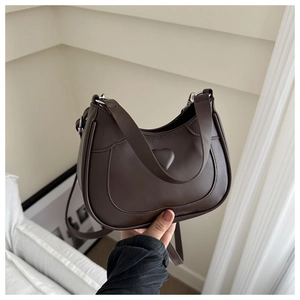 Detail of dark brown PU leather crescent bag with embossed heart and silver hardware