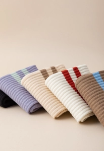 Detail showing stacked ribbed knit yoga socks with various striped patterns and colors