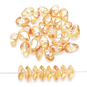 Macro detail of teardrop glass beads in iridescent orange with smooth straight hole