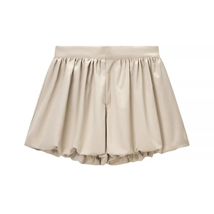 Detail view of beige satin shorts with pleated bubble hem and smooth waistline finish