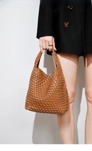 Detail of hand-woven caramel tote bag in intrecciato style with sharp shadow effect