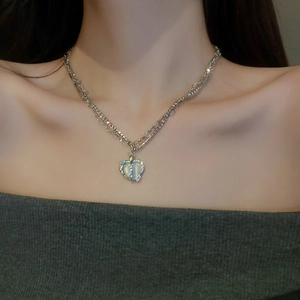 Silver heart necklace with cat-eye stone and small zircons worn by a model