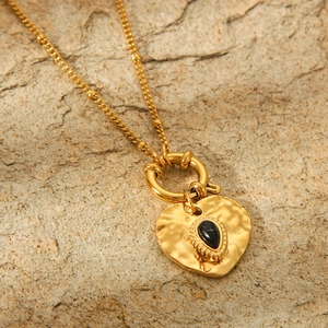 French vintage heart pendant necklace in gold with black stone on stone texture