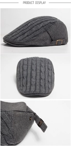 Detail view of dark grey knitted beret hat with cable texture and metal buckle adjustment