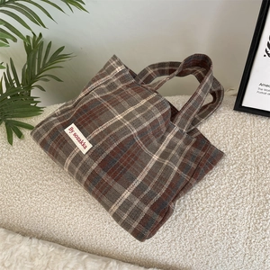 Detailed view of the vintage plaid handbag featuring a woven texture and By sozakka label