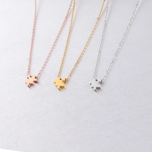 Three puzzle piece pendant necklaces in rose gold, gold, and silver stainless steel