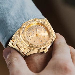 Macro shot of gold-tone iced out watch featuring diamond encrusted bezel and octagonal dial
