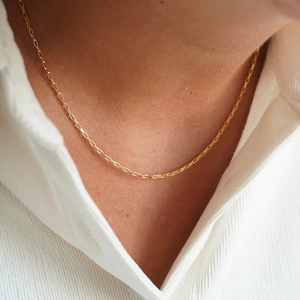 Detailed close-up of a 14K gold plated stainless steel box chain necklace on white shirt