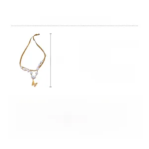 Dettaglio della collana a farfalla placcata in oro con perle sintetiche e catena in titanio