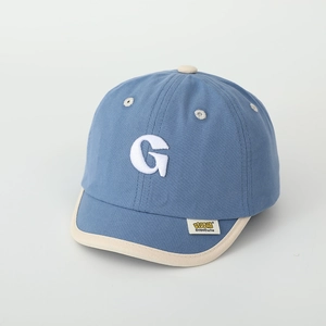Detailed close-up of blue cotton baseball cap for kids with white G letter embroidery