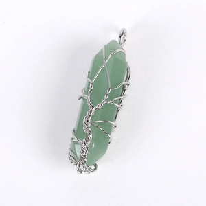Detail of green crystal hexagonal pendant wrapped in silver wire tree of life design