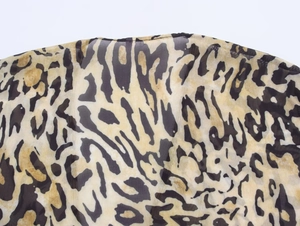 Detailed macro view of lightweight leopard print chiffon fabric texture and breathable material