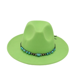Detailed close-up of emerald green fedora hat with turquoise bead and woven band decoration