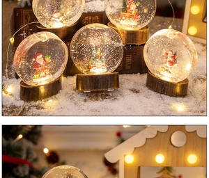Détail d'une boule à neige de Noël lumineuse avec le Père Noël et décor de forêt