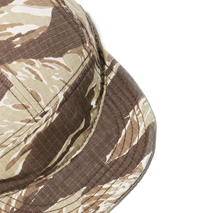 Gros plan détaillé montrant le motif camouflage tigre et les coutures d'une casquette en toile