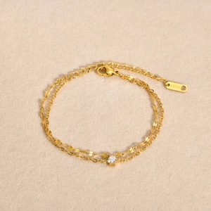 Détail d'un bracelet double couche plaqué or 18k avec zircon rond en acier inoxydable
