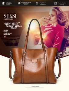 Close-up of brown oil wax leather tote bag with decorative U-shaped pocket and handles
