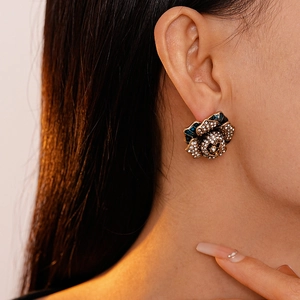 Detail of vintage flower stud earring with blue enamel petals and sparkling rhinestones